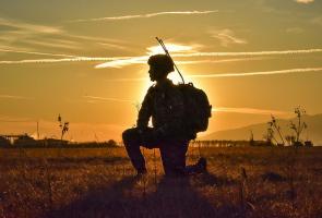 Backlit kneeling soldier